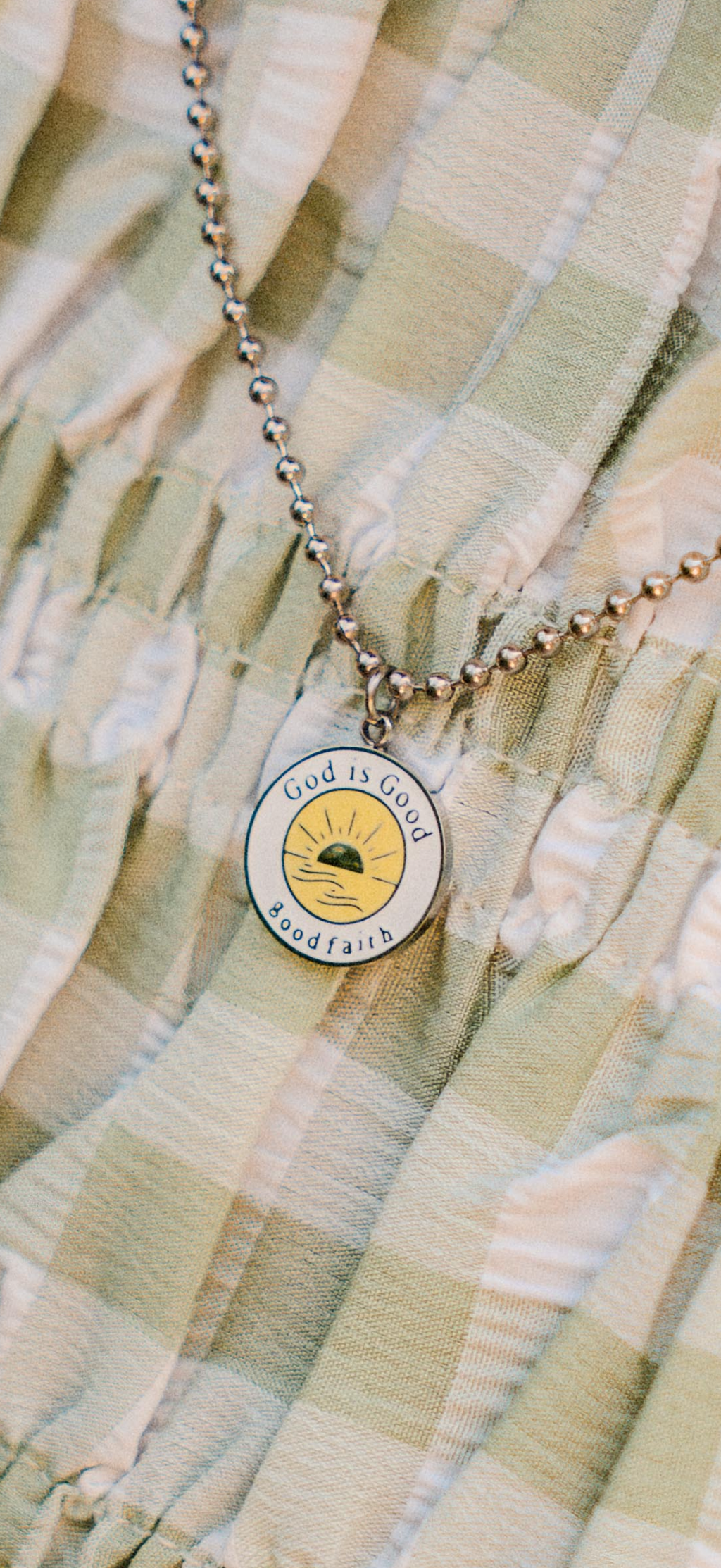 Silver Necklace with a yellow and white pendant on a textured fabric background