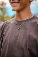 boy wearing necklace outdoors 