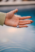 Hand holding a necklace with a blurred background