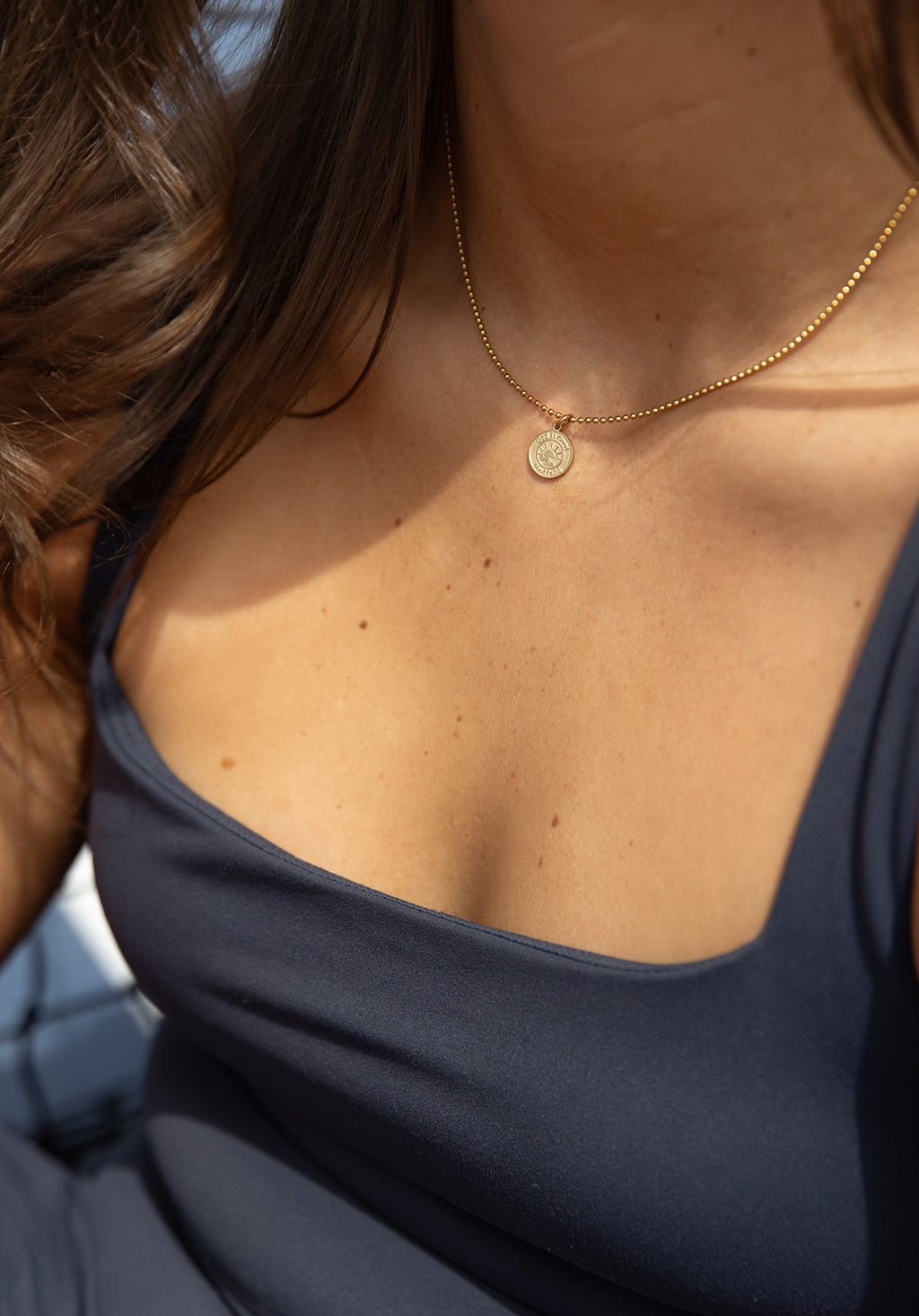 gold God is good necklace on woman in athletic wear